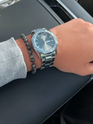 Silverfärgad klocka - Stilren klocka, silverfärg med metallarmband och svart urtavla. Klockan har dag- och datumvisning samt tydliga markeringar. Perfekt accessoar för dig som gillar en klassisk look.