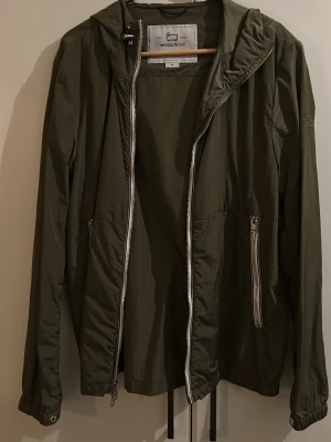 Olivgrön vindjacka från Woolrich - Lätt olivgrön vindjacka från Woolrich med huva…  mycket bra skit, svårt att hitta online… Nypris: 3600kr… storlek M