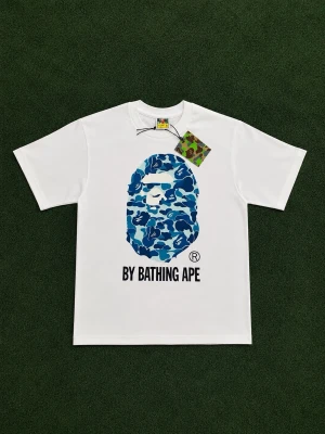Vit BAPE t-shirt med blått camotryck - Säljer en vit t-shirt från BAPE med det ikoniska apansiktet i blått camomönster på bröstet. Storlek S men den passar M också. 100% bomull så den är skön och luftig och perfekt om du vill ha en streetwear look. Påse och tags följer med vid köp! 