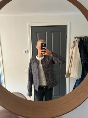 Grå jacka uniqlo S - Säljer en stilren grå dunjacka med quiltat mönster. Jackan har rak passform, rund halsringning och dragkedja framtill. Perfekt för kalla vinterdagar och enkel att matcha med olika outfits. Den är från uniqlo i storlek S.
