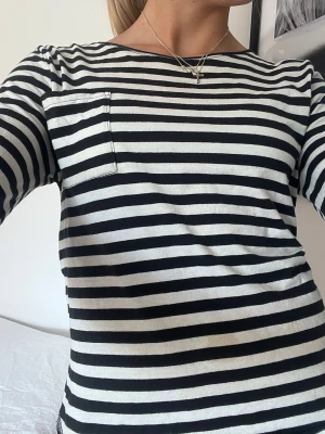 Randig långärmad topp i bomull - Säljer en svartvit randig långärmad topp med rund hals och en ficka på höger bröst!💕
