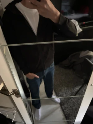 Svart hoodie med dragkedja - Säljer en enkel svart hoodie med dragkedja framtill och huva. Hoodien har en klassisk passform och är perfekt att slänga på sig över en t-shirt. Materialet är mjukt och bekvämt, troligen bomull. Skulle säga att den passar upp till storlek 170. Pris går att diskutera. Skriv om ni har några funderingar🥰