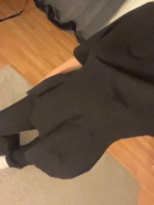 Svart topp med trekvartsärm - Snygg svart topp med trekvartsärm och rund hals. Modellen har en lätt utsvängd passform nedtill och är enkel att styla till olika looks. Perfekt för dig som gillar stilrena och klassiska plagg.