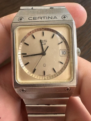 Certina DS-2 vintage klocka i silver - Säljer en klassisk Certina DS-2 klocka i silverfärgat stål med fyrkantig boett och länkarmband. Urtavlan är ljus med datumfönster och tydliga svarta index. Baksidan har Certinas sköldpaddssymbol och info om safirglas och vattentäthet.