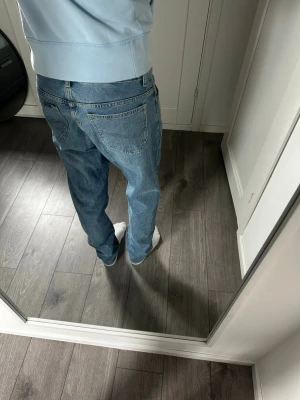Blåa Lee jeans  straight fit w30 L33 - Klassiska Lee Rider jeans med snygg och tidlös passform. Jag är 180 cm / 70 kg och bär jeansen på bilderna, så passformen syns tydligt.  Jeansen är i mycket fint skick utan defekter. Inga hål, fläckar eller andra skador.  Modell: Lee Rider Storlek: W30 L33 Nypris: ca 1 000 kr Skick: Mycket fint skick  Mått:  * Längd: 105 cm * Bredd: 40 cm * Benbredd längst ner vid ankeln: 18 cm  📦 Postas inom 24 timmar! 📸 Se bilder för skick och passform.