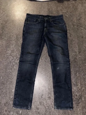 Mörkblå Levi's 511 slim jeans - Snygga mörkblå jeans från Levi's modell 511 med slim fit passform. Klassisk femficksdesign, diskreta slitningar och Levi's ikoniska läderpatch bak i midjan. Perfekta för en trendig och avslappnad stil.