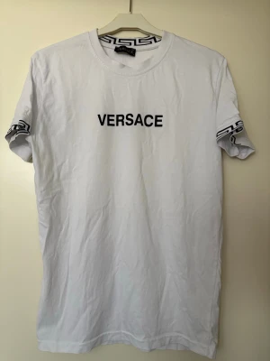 T-shirt med tryck på. - Vit T-shirt med tryck på bröstet och ärmarna. Den är aldrig använd, bara tvättad och legat i garderob. Så ny, bara skrynklig.
