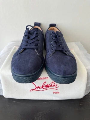 Mörkblå mockasneakers från Louboutin -  Snygga marinblå sneakers från Christian Louboutin(SKORNA ÄR ÄKTA KVITTO FINNS)  i mocka med matchande snörning och diskret broderad logga på hälen. Skorna har en klassisk låg siluett och en mörkblå sula som ger en clean och exklusiv look. Pris är inte spikat i sten!? Tveka inte på minsta lilla fårga (fraktar samma dag)
