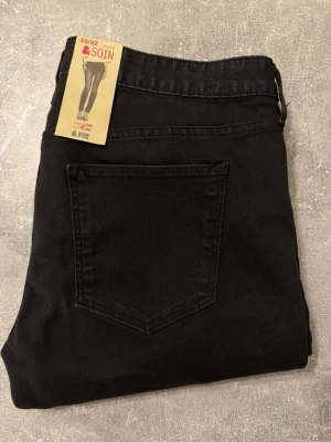 Svarta skinny jeans från SQIN - Säljer ett par svarta skinny jeans från SQIN med klassisk femficksdesign och normalhög midja. Jeansen är i stretchigt material för en bekväm passform och har en enkel bakficka utan detaljer. Perfekta för en clean och stilren look.