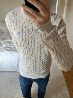 Beige kabelstickad tröja från Morris - Säljer en snygg sjukt snyggt stickad tröja från Morris. Tröjan är i storleken L och i ett mycket fint skick utan defekter! 😁✌🏼        ——————————————————————————                                                                          📐| Storlek: Large                                                             👖| Märke: Morris Stockholm                                      🔎| Skick: Fint skick!                                                     ✍🏻| Skriv om du har några frågor