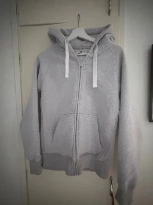 Russemerch zip hoodie - Ljusgrå Russemerch hoodie som jag inte använder längre, och bara använt några gånger, köpte i april