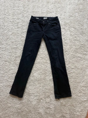Svarta bootcut jeans från LTB - Snygga svarta jeans från LTB i modellen Valerie. Jeansen har klassisk femficksdesign, normal midja och bootcut-ben. Tillverkade i mjukt denimtyg som sitter skönt och passar till många olika stilar. Perfekta för dig som gillar en tidlös look.