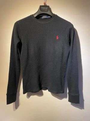 Polo Ralph Lauren tröja, strl XS - Säljer en stickad tröja från Polo Ralph Lauren i svart färg. Tröjan är i bra skick utan hål osv.              Storlek: M, sitter som en XS med långa ärmar.                                       Tröjan är självklart äkta och skickas inom 24h efter köp✅Hör av er vid minsta fundering!