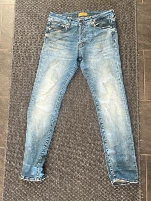 Ljusblå slim fit jeans från jackandjones -  Jack and Jones jeans,Snygga ljusblå jeans med tvättade detaljer. Modellen är slim fit med klassiska fem fickor och normal midja. Jeansen har en modern look och är tillverkade i denim, perfekt för en avslappnad stil.