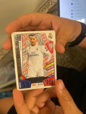 Match Attax Cristiano Ronaldo kort - Säljer ett Match Attax samlarkort med Cristiano Ronaldo från Real Madrid. Kortet har färgerna vitt, rött och blått med statistik och klubbmärke. Perfekt för dig som samlar på fotbollskort eller gillar Champions League.