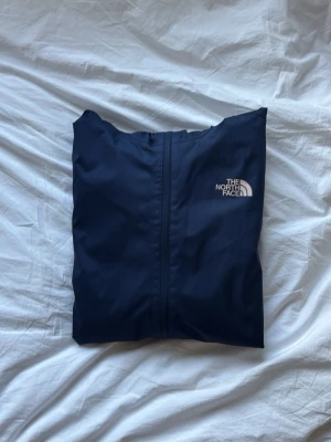 The North Face DryVent skaljacka  - Snygg och stilren marinblå skaljacka från The North Face med DryVent-teknologi. Jackan är i mycket fint skick och knappt använd. Perfekt som regn- och vindjacka för vardag, friluftsliv eller andra utomhusaktiviteter.