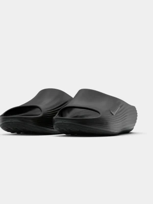 Svarta tofflor  - Säljer ett par svarta tofflor med modern, chunky design och diskret Swoosh-logga på sidan. Tillverkade i ett mjukt och flexibelt syntetmaterial som ger skön komfort. Perfekta för chill dagar hemma eller snabba ärenden.
