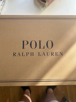Polo Ralph Lauren Train 89 sneakers - Snygga svarta sneakers från Polo Ralph Lauren i modellen Train 89. Skorna har en mix av mocka och oxfordtyg, med röda detaljer och logga på sidan. Låg profil och sportig design som passar till många olika stilar.
