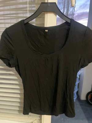 Svart basic t-shirt med v-ringning - En enkel svart t-shirt med v-ringad hals och korta ärmar. Tillverkad i mjuk bomull 