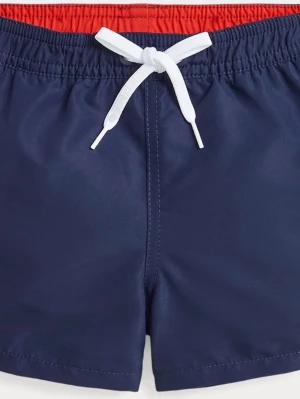 Polo Mörkblå badbyxor - Snygga mörkblå badbyxor med röd resår i midjan och vit dragsko framtill. Klassisk passform med korta ben och en ficka bak med knapp. Perfekta för stranden eller poolen. Tillverkade i snabbtorkande material.