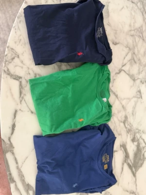 Tre färgglada t-shirts med logga - Säljer tre t-shirts i olika färger.(priset som läggs upp är för alla 3 tillsammans)