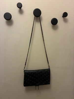 Svart axelväska - Svart väska med silver detaljer från misako, den har två stora fack. Går inte längre att köpa online. Använd några gånger. Inga tecken på användning.