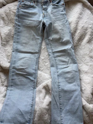 Ljusblå Levi's 501 jeans - Klassiska ljusblå Levi's 501 jeans med rak passform och fem fickor. Jeansen har knappgylf och är tillverkade i slitstark bomullsdenim. Perfekta för en avslappnad och tidlös stil. 