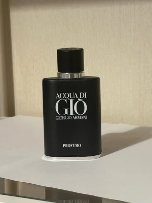 Acqua di Giò Profumo parfym - Acqua di Giò Profumo från Giorgio Armani är en elegant parfym i en matt svart flaska med silverdetaljer. Flaskan har en stilren, rektangulär form och tydlig logotyp framtill. Doften beskrivs som fräsch, aromatisk och träig – perfekt för dig som gillar exklusiva parfymer.