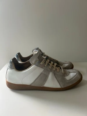 Maison Margiela Gats Skor - Snygga sneakers i vitt från margiela, skorna har använts sällsynt i 1,5 år. Inga stora defekter förutom lite smuts samt fläckar från selvedge denim, och creases. OBS: DUST BAGS INGÅR (Ingen box dock). Hör av gärna vid intresse🙌