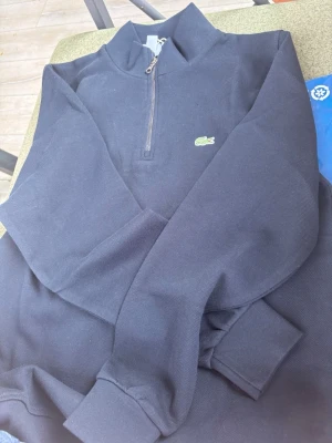Svart half-zip hoodie från Lacoste - Hej säljer denna Lacoste half zip. Den är helt ny och oanvänd 