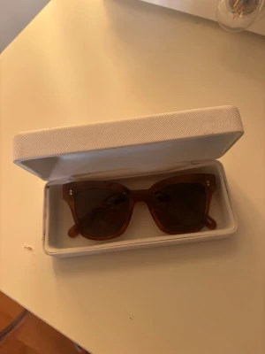 Bruna solglasögon från CHIMI - Snygga bruna solglasögon från CHIMI med fyrkantig form. Kommer i ett stilrent vitt fodral med CHIMI-logga. Perfekta för soliga dagar och ger en cool vibe till din outfit.