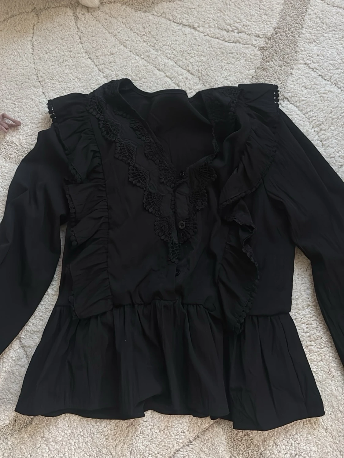 Svart blus med volanger och spets