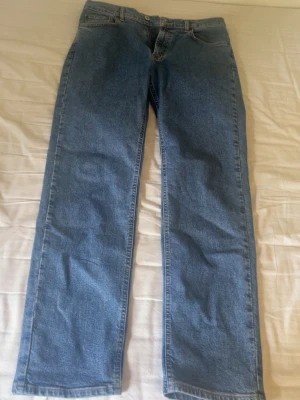 Blå jeans i Relaxed fit i väldigt bra skick - Ett par blå Jeans i jättebra skick köpta från Dressman 