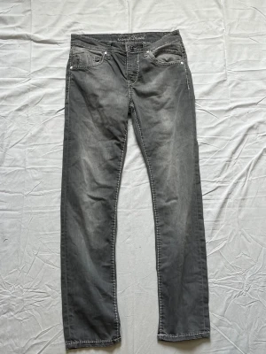 Grå vintage jeans  från Camp David - Snygga grå jeans från Camp David med raka ben och tydliga vita kontrastsömmar. Klassisk femficksmodell och bälteshällor. Jeansen har en tvättad look som ger en cool och avslappnad stil. Perfekta för dig som gillar streetwear och casual vibes. 