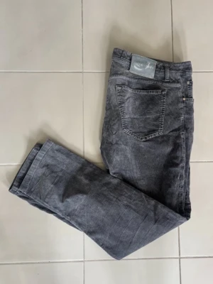 Jeans Jacob Cohen  - Mörkgråa jeans från Jacob Cohen i bra skick! Väldigt funktionell passform och badgen är i en läcker turkos färg! Ett par väldigt mångsidiga jeans som passar till allt. Längd - 103 cm och bredd - 51 cm.