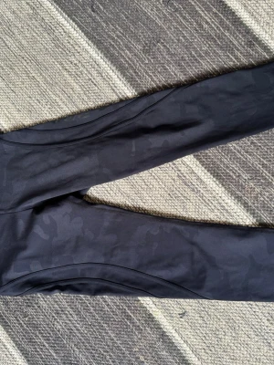 Svarta leggings från Better Bodies - Snygga svarta leggings från Better Bodies med diskret camomönster. Tillverkade i stretchigt funktionsmaterial som sitter tight och bekvämt. Perfekta för träning eller chill. Hög midja och sömmar som framhäver formen.
