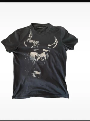 Svart Givenchy t-shirt med tryck - Svart t-shirt från Givenchy Mycket bra skick med tanke på ålder enda missprydnande är några små hål