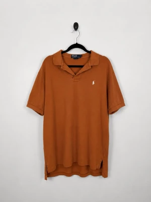 Vintage Polo Ralph Lauren Piké M Rostbrun Burnt Orange Relaxed Fit 90s Y2K HerrVintage Polo Ralph Lauren Piké M Rostbrun Burnt Orange Relaxed Fit 90s Y2K HerrVintage Polo Ralph Lauren Piké M Rostbrun Burnt Orange Relaxed Fit 90s Y2K Herr - • Storlek: M • Färg: Orange • Passform: Relaxed Fit  • Krage: Klassisk pikékrage • Material: 100% bomull  Skick: Plagget är i ett bra skick med fläckar som syns på bild. Eventuella anmärkningar anges alltid tydligt i beskrivningen och visas på bilderna.  Nypris: Cirka 1 500 kr.  📦 Skickas snabbt och packas omsorgsfullt. 💬 Hör gärna av dig om du har frågor eller vill se fler bilder. 🤝 Samfrakt erbjuds vid köp av flera plagg – kika gärna in mina andra annonser!• Storlek: M • Färg: Orange • Passfor