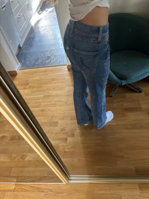 Blå raka/utsvängda jeans med hög midja - Säljer ett par klassiska blå jeans med hög midja och raka ben. Jeansen har bakfickor med snygga sömmar på. Perfekta till vardags och passar till det mesta. Jeansen är i barnstorleken 164 men passa mig som har 36-38 i jeans. Dessa har inte används så mycket men köptes för ett tag sedan!