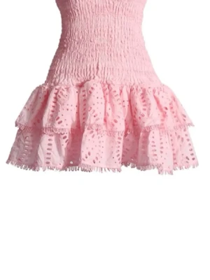 Rosa kort volangklänning - Supersöt rosa kort klänning med smockad överdel och volangig kjol i broderad bomull. Perfekt för varma dagar och ger en gullig och trendig look med sina detaljerade spetsvolanger.
