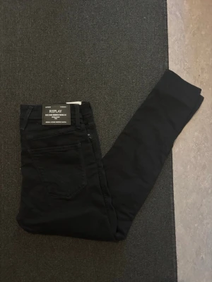 Replay jeans - Säljer ett par svarta jeans från Replay i modellen Bronny med super slim fit. Jeansen har klassisk femficksdesign och är tillverkade i ett stretchigt material för en tajt och bekväm passform. Perfekta för dig som gillar en smal siluett. Helt nya med prislappen kvar