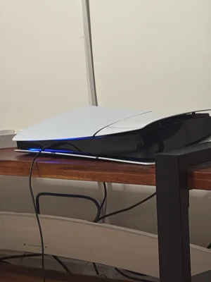 PlayStation 5 spelkonsol - Säljer en PlayStation 5 spelkonsol i vit och svart design med futuristiska former. Konsolen har LED-belysning och är tillverkad i plast. Perfekt för gaming och multimediaupplevelser.