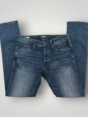 slim fit jeans från Jack & Jones 28/30 - 28/30     Modellen: slim glen                                                                     Snygga blå slim fit jack and jones jeans med lätt tvättade detaljer och klassisk femficksdesign. Jeansen har normal midja och raka ben, tillverkade i stretchigt denim för extra komfort. Perfekta för en avslappnad och trendig look.