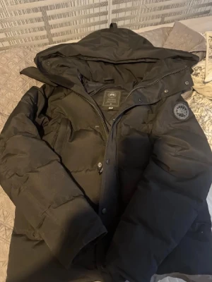 Canada goose svart jacka - Fanns några skador men inga synliga annars inga fläckar elle nåt borde nog passa någon som är ungefär 170-175 60kg. Det är egentligen två fickor, men mellanväggen gick sönder så de blev som en stor ficka istället och de kommer ut fjäder från fickan.