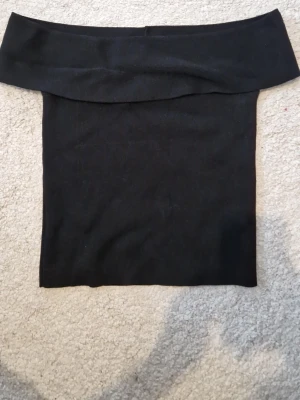 Svart off shoulder topp  - En enkel och stilren svart off-shoulder topp med tight passform. Toppen är från Gina Tricot och passar till allt