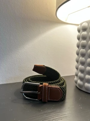 Grönt flätat bälte - Tja jag säljer ett helt nytt flätat bälte i storlek 105•3,5cm. I min profil finns det några andra bälten i olika färger och andra go saker. Vid köp så postar jag inom 24h.