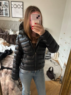 Svart jacka  från Colmar - Snygg svart vinterjacka från Colmar som är matt/glansig med huva. Jackan har en silver/grå dragkedja framtill och logga på ärmen. Perfekt inför vintern. Väldigt bra skick, inga defekter. Pris kan diskuteras vid snabbt och smidigt köp!🩷