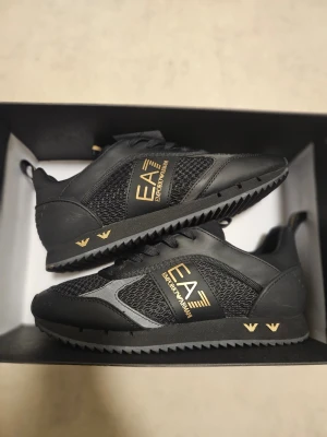 Ea7 Sneakers NYA  - Svarta sneakers från Ea7  Köpte dom precis men dom blir tyvärr för stora för mig så skorna är alltså enbart provade. Strl. 39 1/3 Skickas i original kartong & har tom pappret kvar i skorna. 