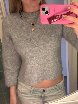 Hm mohair tröja - Mysig ljusgrå stickad tröja med rund halsringning och något kortare, rak passform. Tröjan har långa ärmar och är tillverkad i ett mjukt, fluffigt material som ger en avslappnad look. Perfekt för lager på lager under kyliga dagar. Storlek S men har tyvärr krympt i tvätten! 