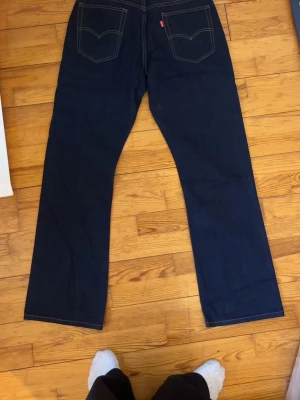 Levi's 517 mörkblå jeans W34 L34 - Säljer ett par klassiska Levi's 517 jeans i mörkblå denim med raka ben och kontrastsömmar. Jeansen har två bakfickor med den ikoniska Levi's-sömmen och röd etikett. Perfekta för dig som gillar tidlös stil och schysst passform. skulle säga att de. passar mer w32